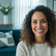A smiling woman in her late 30s looking at the camera, conveying happiness and satisfaction.